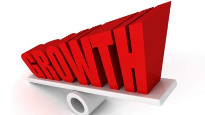 Big red letters on a seesaw spell growth, indicating share price movements for ASX growth shares