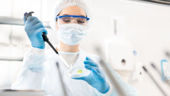 woman carrying out an experiment with a pipette and petri dish