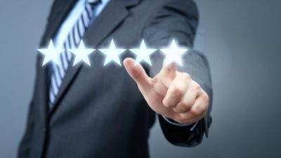 A businessman lights up the fifth star in a lineup, indicating positive share price for a top performer