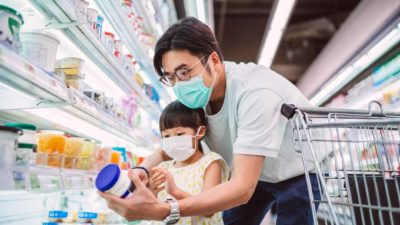 dad and daughter shopping in a supermarket with masks on