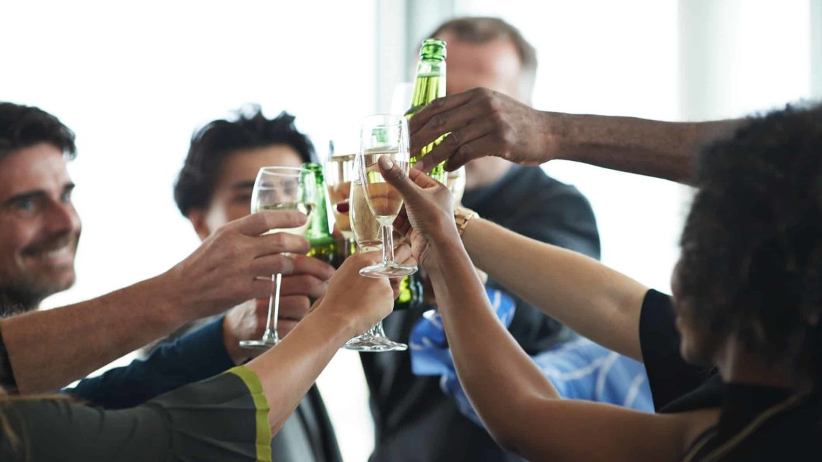 people with drinks clinking glasses in a social setting