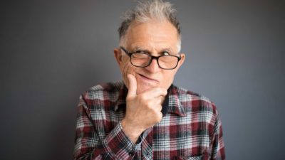 person thinking by holding hand to chin in consideration