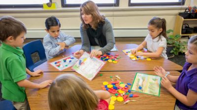 children and teacher in childcare education setting