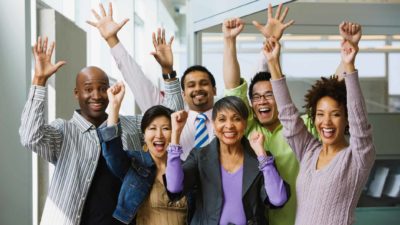people celebrating with arms raised and happy faces