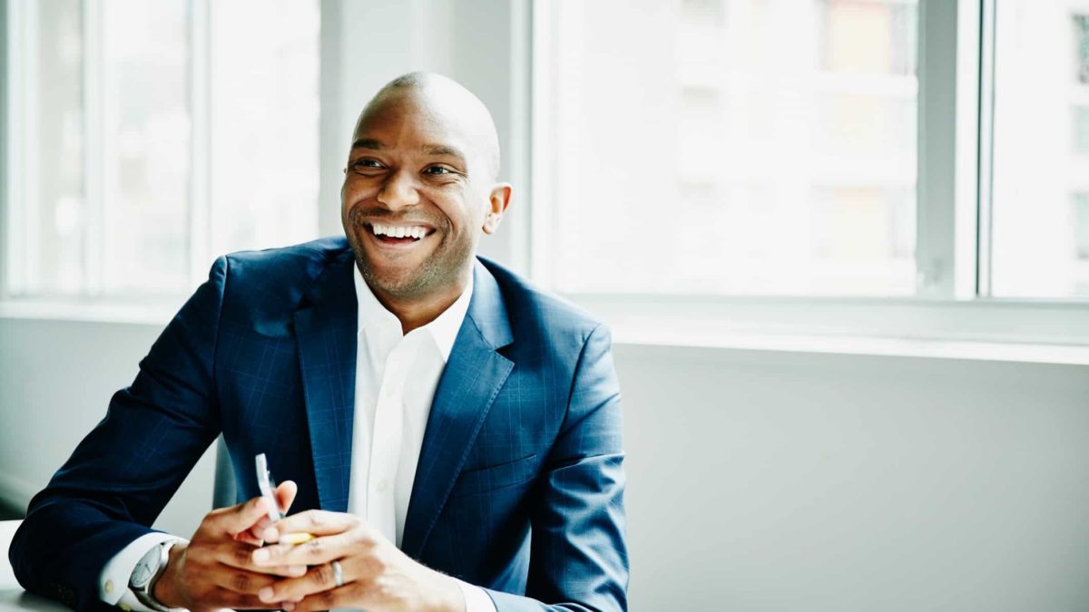 smiling man holding phone technology
