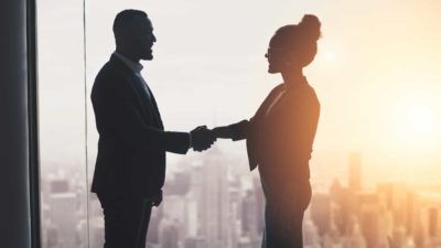 Two business people shaking hands in an office