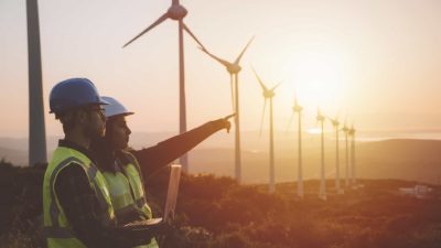 Workers at a wind farm in front of wind turbines