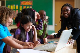 children learning on laptops in classroom
