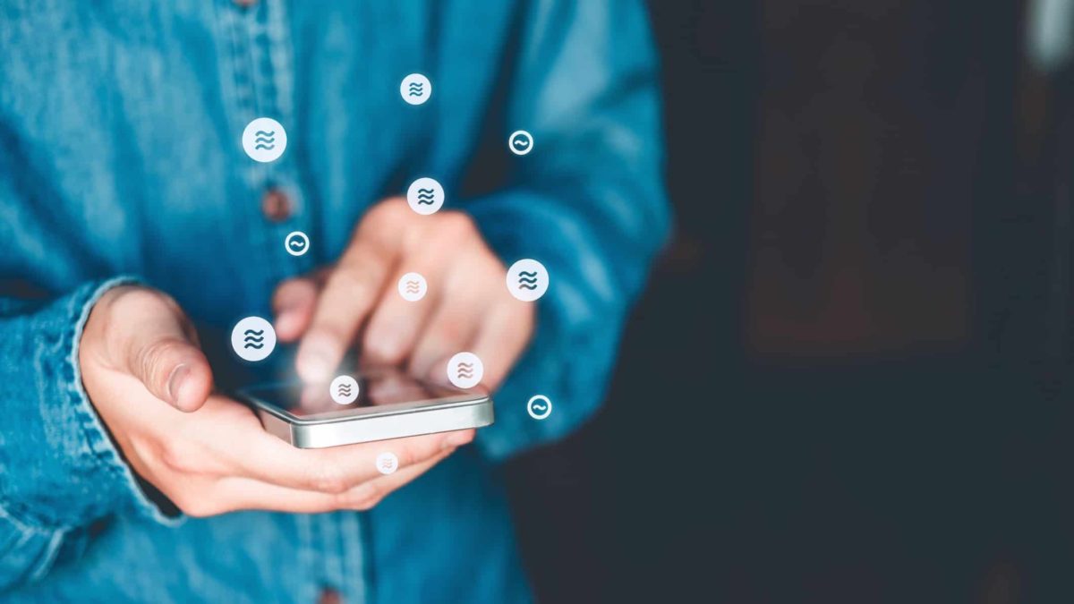 A man handles a transaction on his smartphone using Facebook's new crytocurrency diem