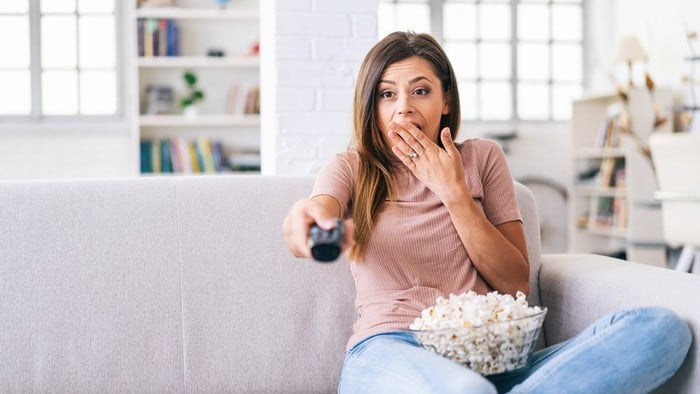 woman looking surprised watching netflix