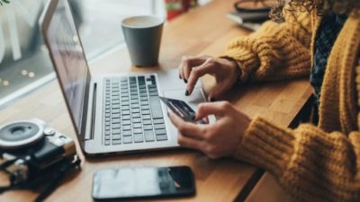 person using their credit card to pay online on a laptop