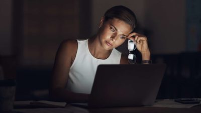 A woman slumped at her computer in a power outage.