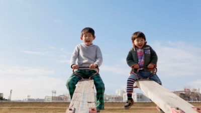 Two boys happy at the top of see saws.
