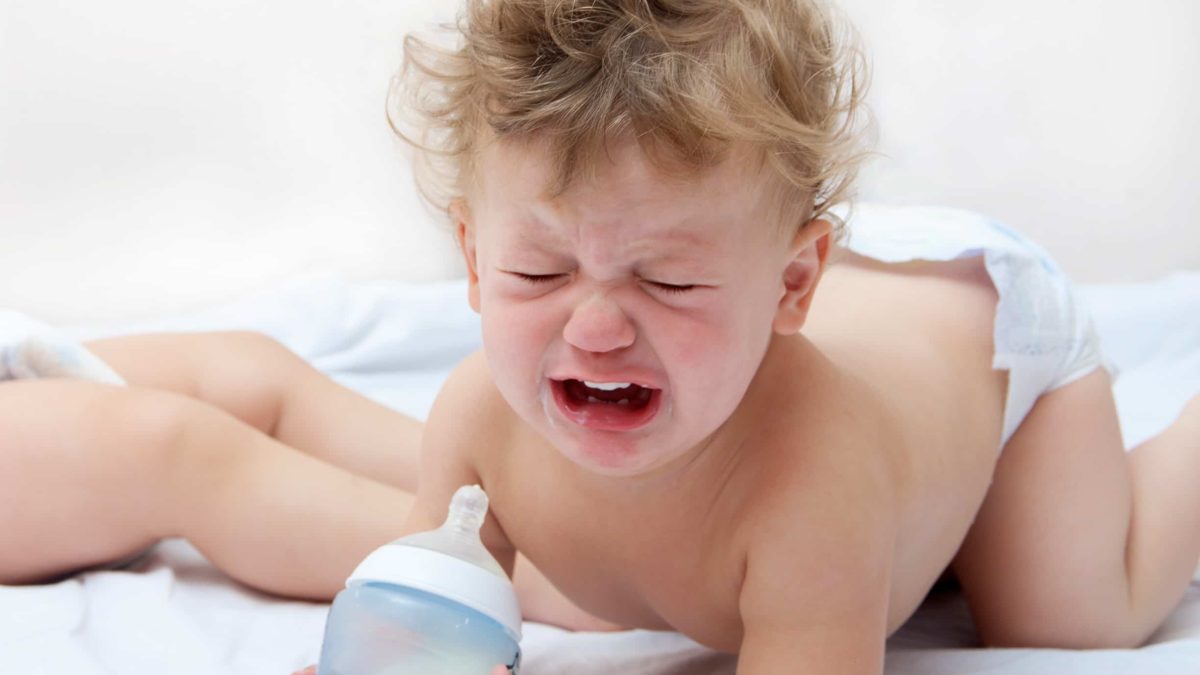 sad baby with bottle, infant formula price drop,