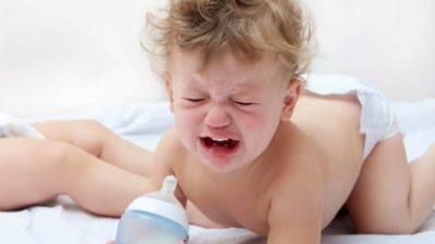 sad baby with bottle, infant formula price drop,