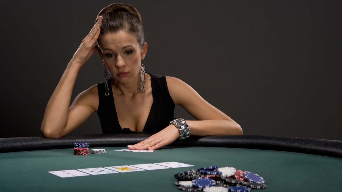 sad gambler sitting at casino table with cards and chips, gambling, casino, loss
