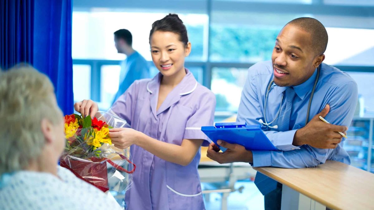 doctor and nurse attend to patient bedside in medical setting