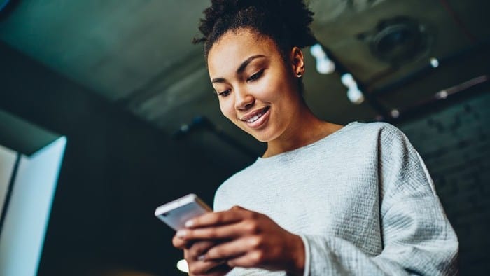 Investor looking at smartphone and considering Evolution's share purchase plan