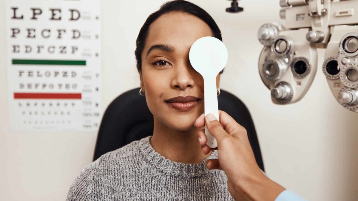 A woman sits inside a cubicle undergoing an eyetest