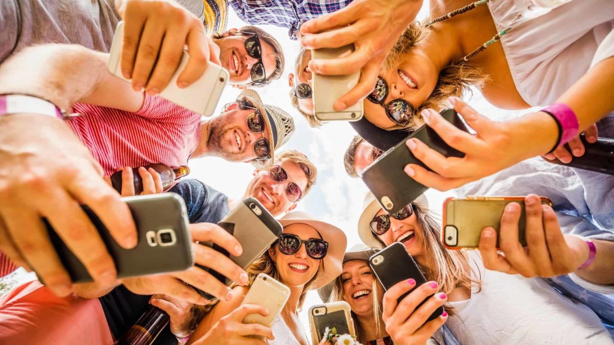 Group of friends trading stocks on their phones. symbolising the 3 most traded ASX 200 shares today