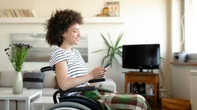woman in wheelchair happy while investing online