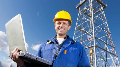 oil rig worker smiling with laptop