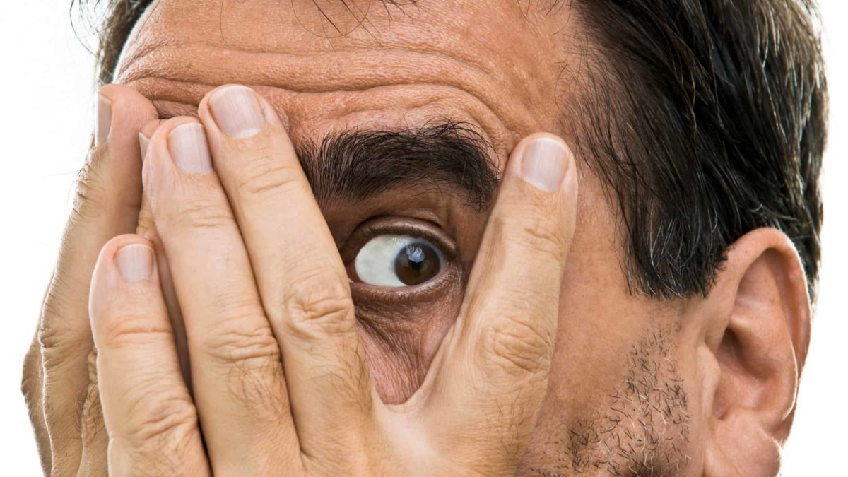 shocked man looks through one eye