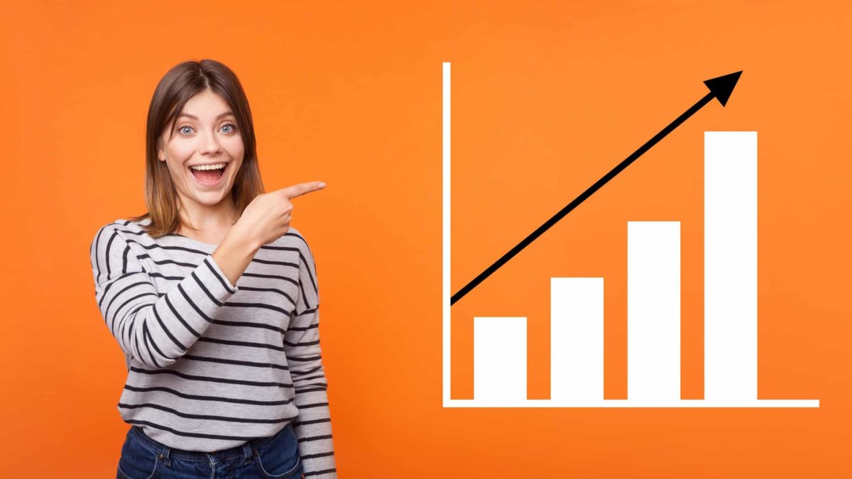 a happy investor with a wide smile points to a graph that shows an upward trending share price