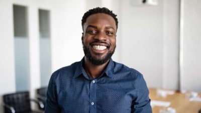 Man with big smile, this employee has had a good experience.