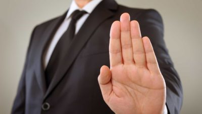 ASX share investor holding up hand in stop motion