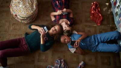 group of kids using facebook on their smartphones