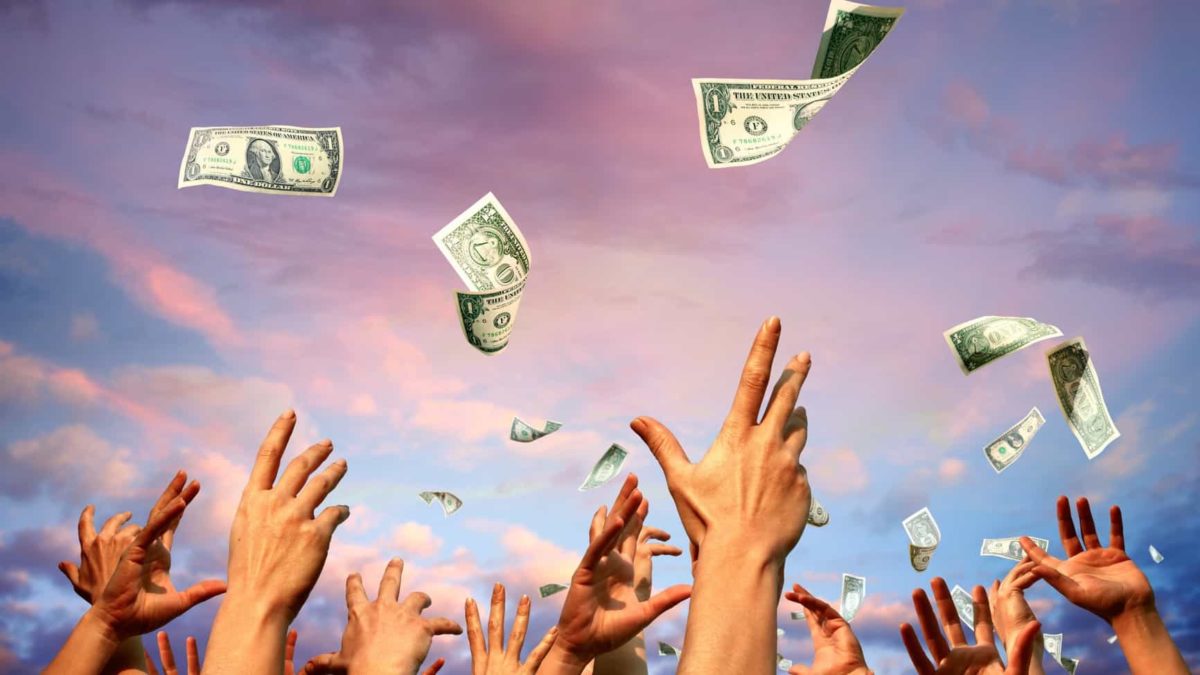 A group of outstretched arms and hands reach for cash banknotes falling from the sky representing the Fortescue dividend paid today