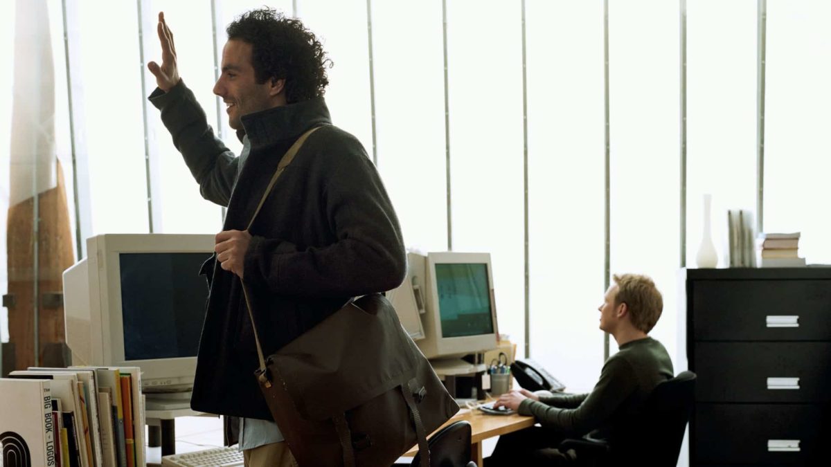 A man waves goodbye as he leaves an office.