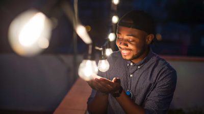 man looks at light bulbs and smiles