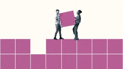 Two people carry a square shape to fit into a block of squares