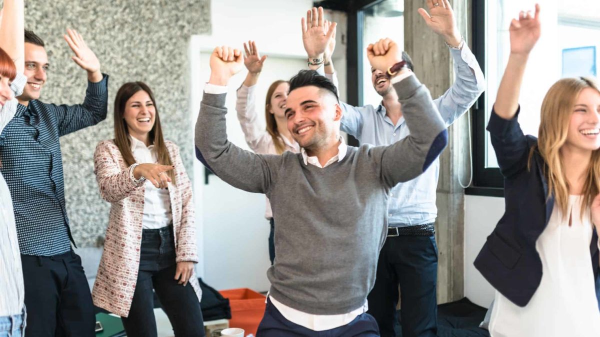 a group of young people dance together with their hands in the air, moving to music.