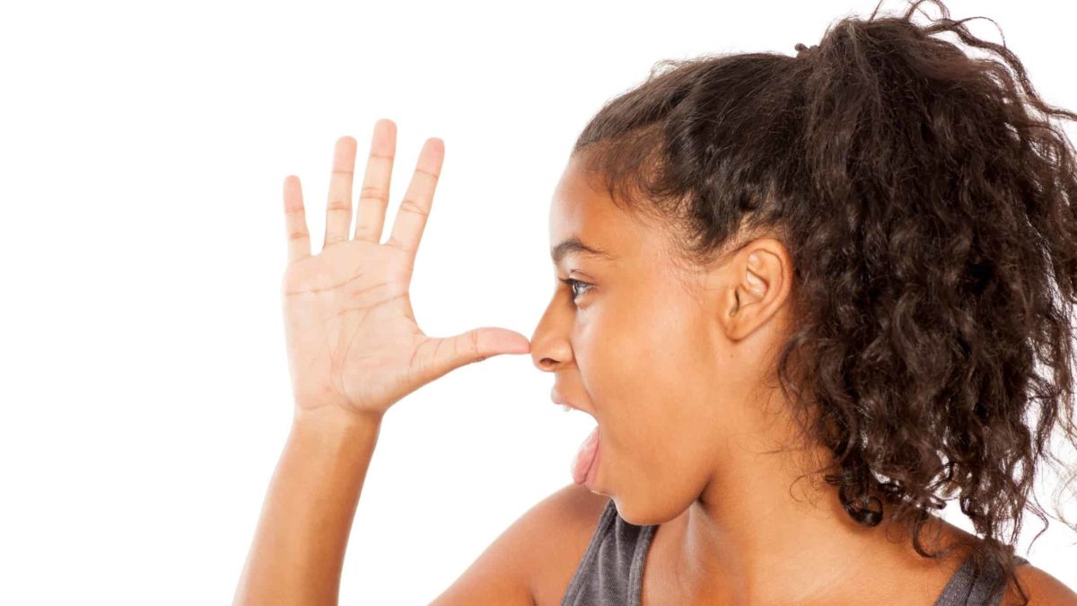 A woman sticks her hand up with thumb to nose.