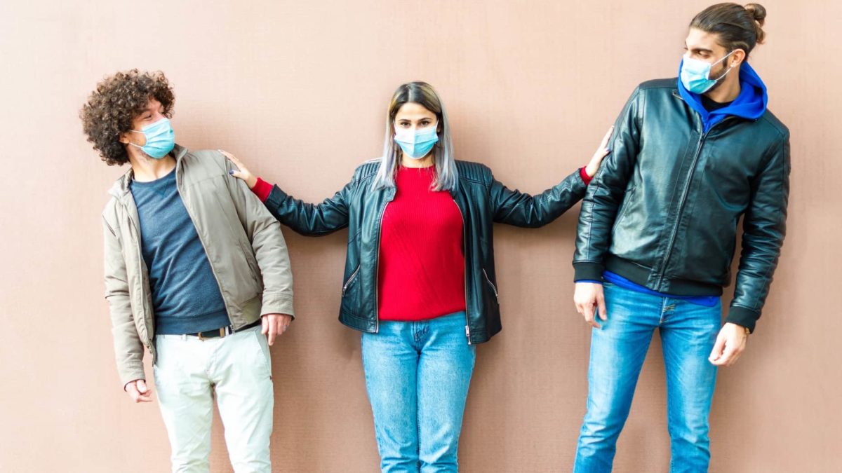A group of young people clowning around wearing COVID-19 masks