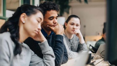 Three workers are not pleased, seeing the lousy news on a computer.