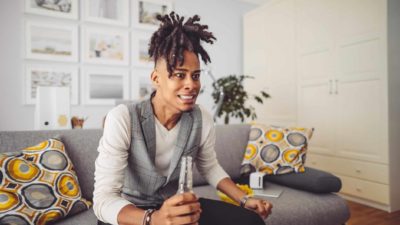 A man sits bolt upright watching something intently on his television.