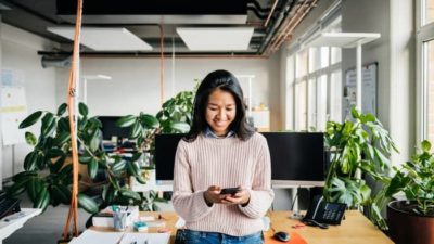 happy woman looking at her smartphone.