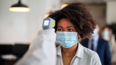 A worker has a temperature test for fever as COVID-19 keeps people at home in lockdown