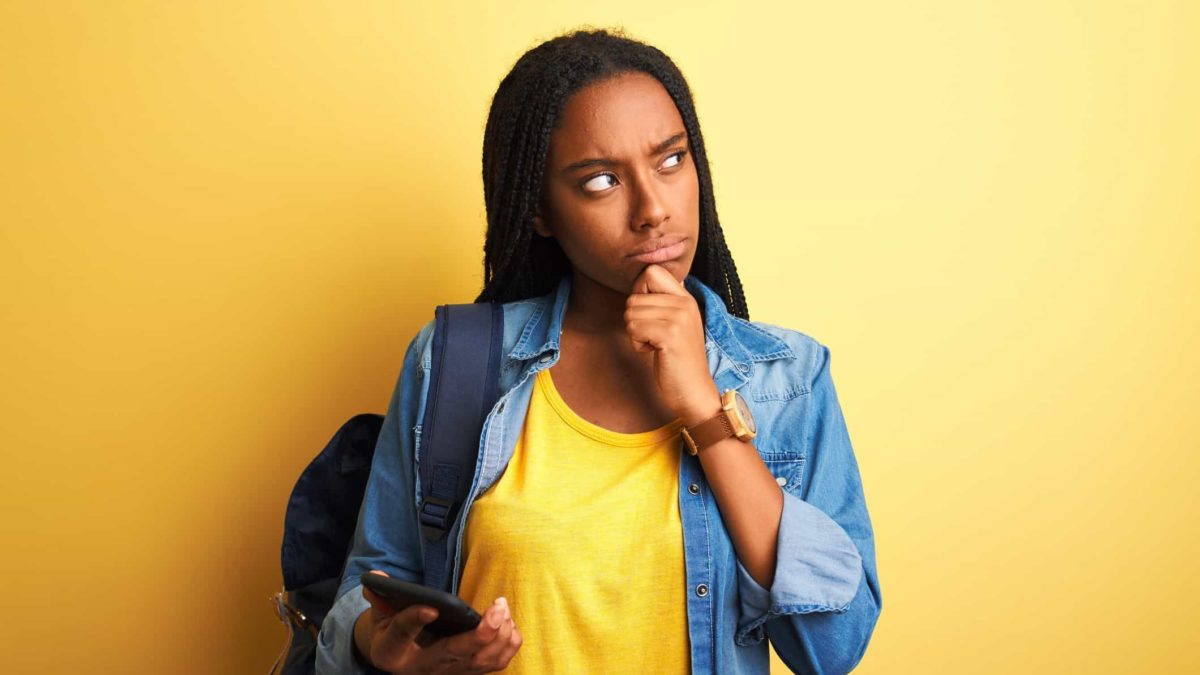 a woman puts her hand to her chin and looks to the side deep in thought as though pondering something significant.