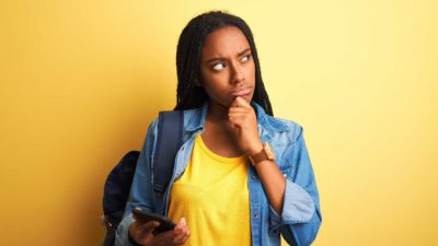 a woman puts her hand to her chin and looks to the side deep in thought as though pondering something significant.