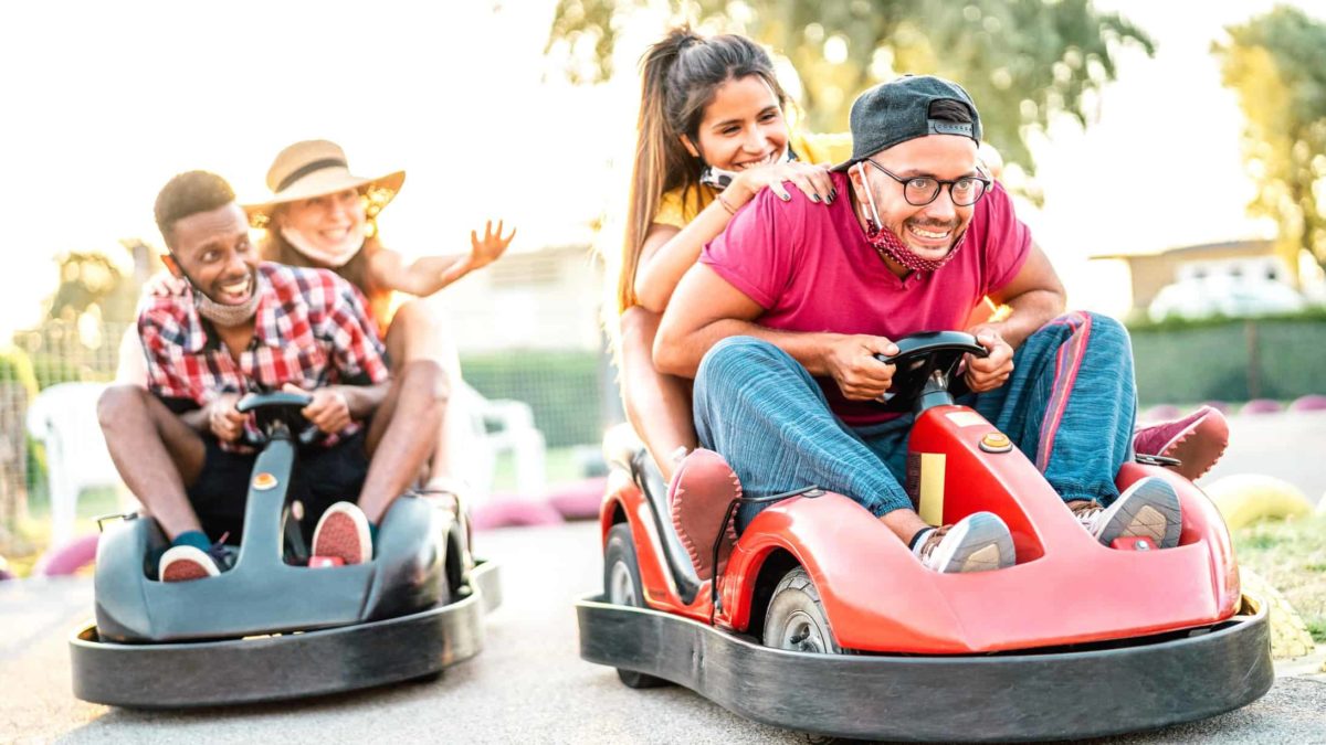 Two couples having fun racing electric dodgem cars around a track