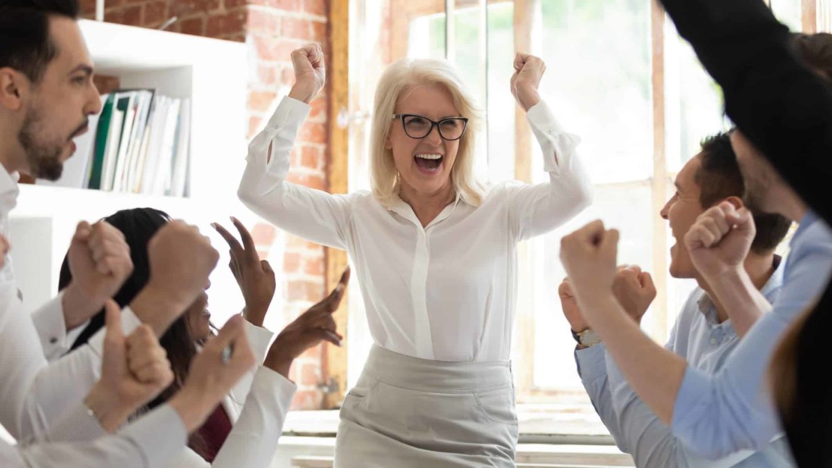 Team celebrating corporate success screaming with joy.