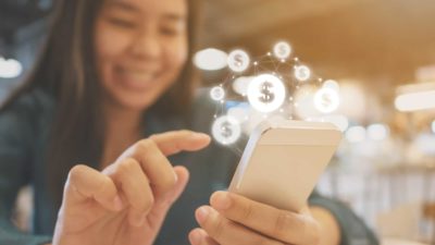 A woman uses her mobile phone to make a purchase.