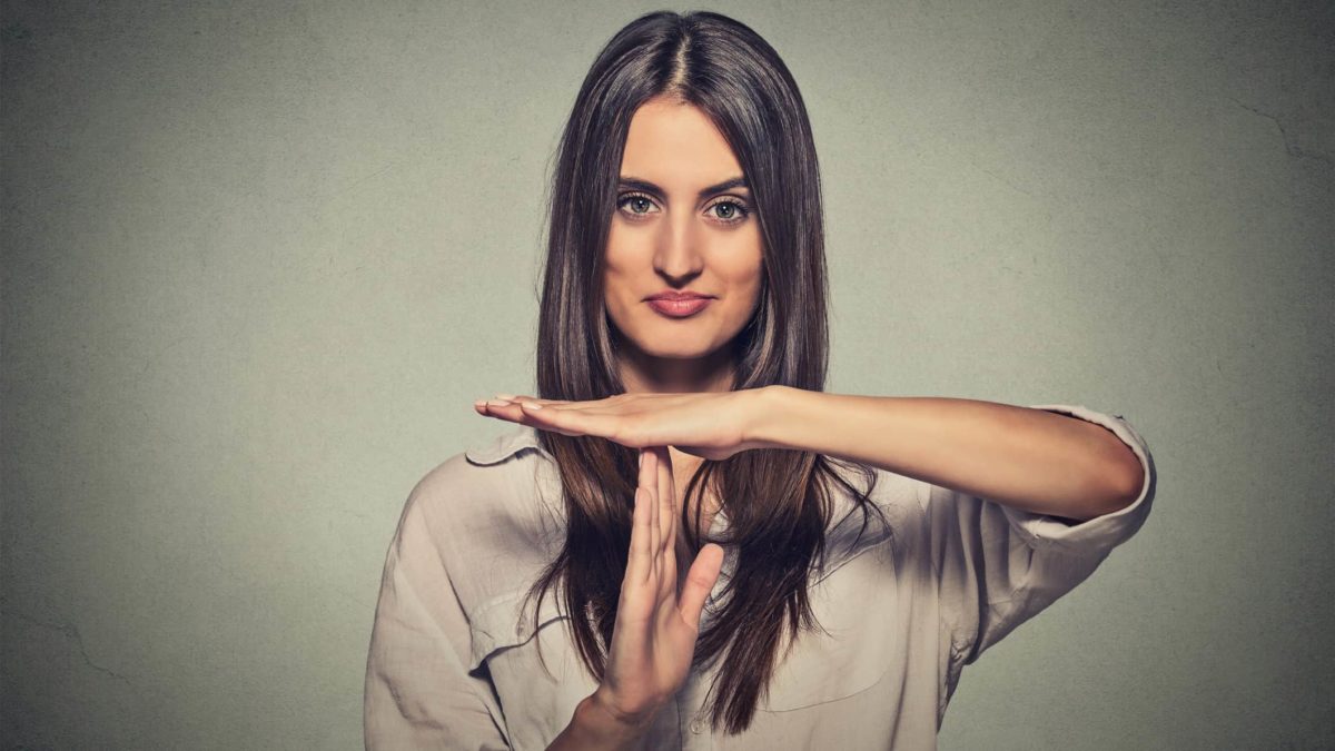 an attractive woman gives a time out signal with her hands, holding them in a T shape, indicating a trading halt.