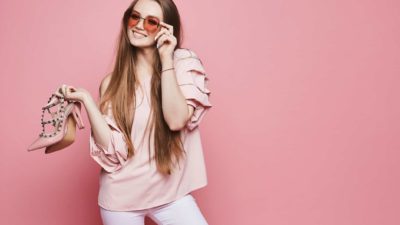 Happy woman holding high heels.