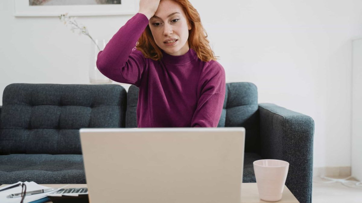 Disappointed woman with her head on her hand.